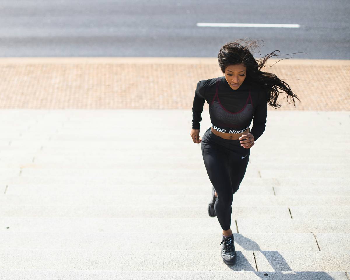 health wellness beginner running how to - woman smiling during run-walk interval in park